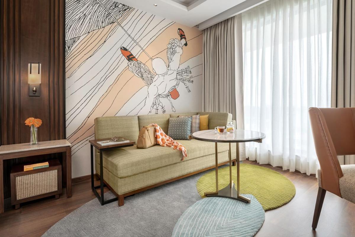 a living room with a couch and a table at Hyatt Centric Rajpur Road Dehradun in Dehradun