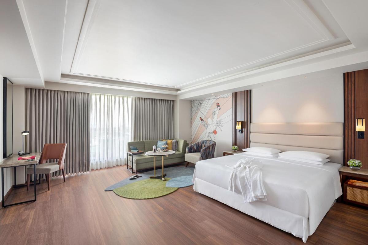 a bedroom with a large white bed and a desk at Hyatt Centric Rajpur Road Dehradun in Dehradun