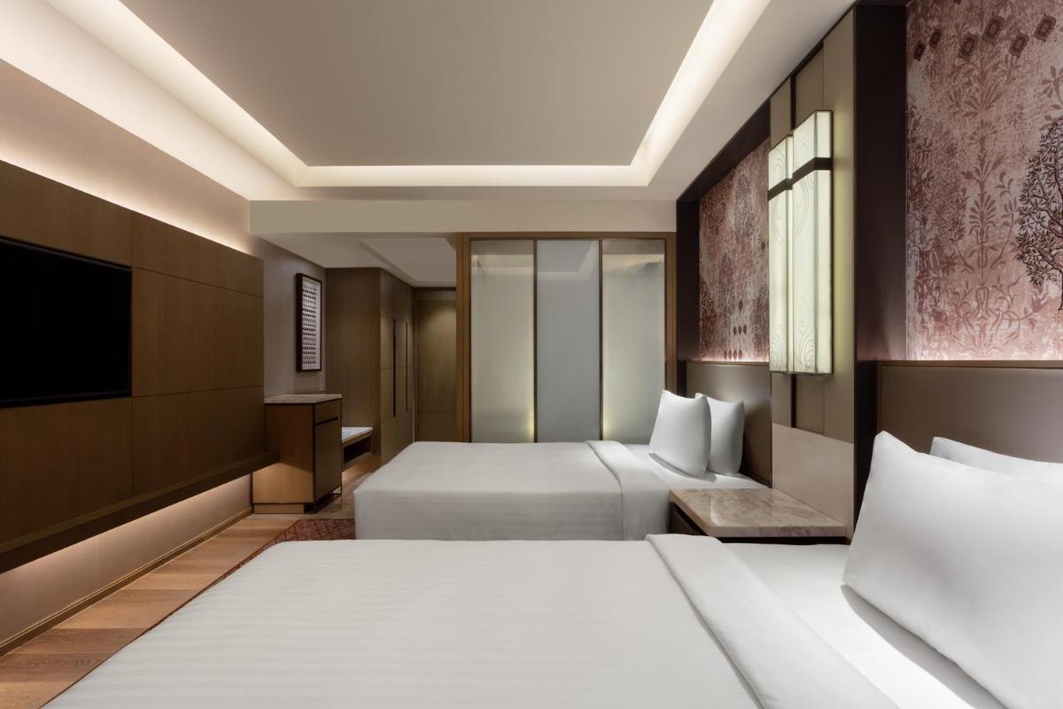 a hotel room with two beds and a tv at Courtyard by Marriott Amritsar in Amritsar