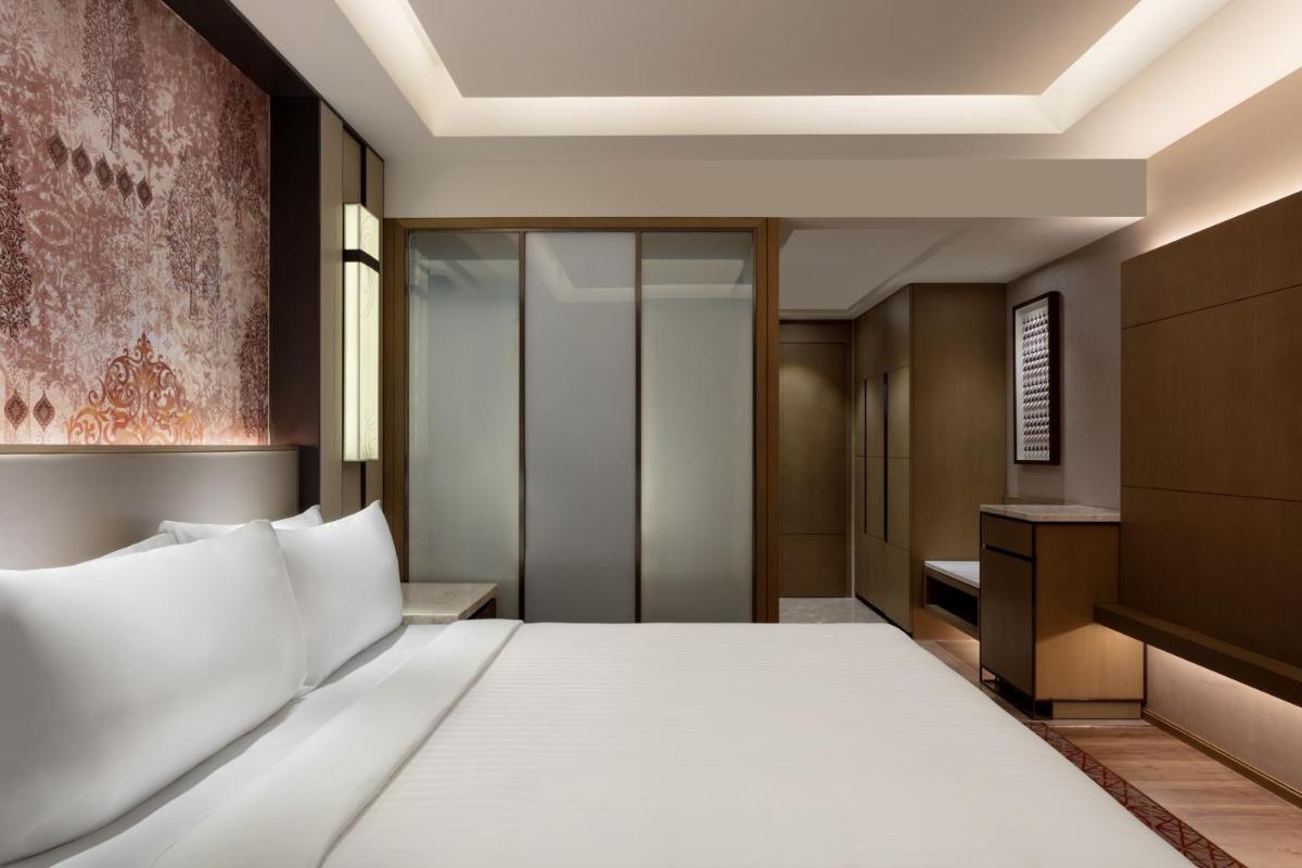 a hotel room with a bed and a walk in closet at Courtyard by Marriott Amritsar in Amritsar