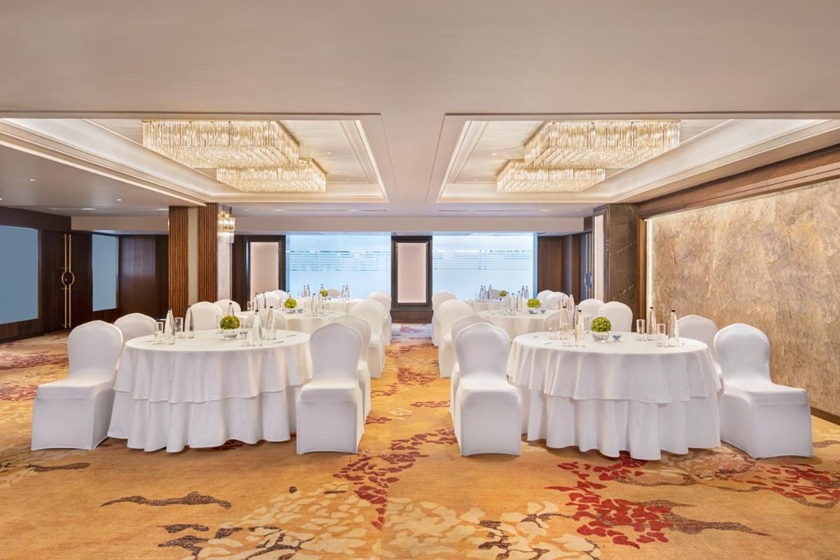 a conference room with white tables and white chairs at Hyatt Centric Rajpur Road Dehradun in Dehradun