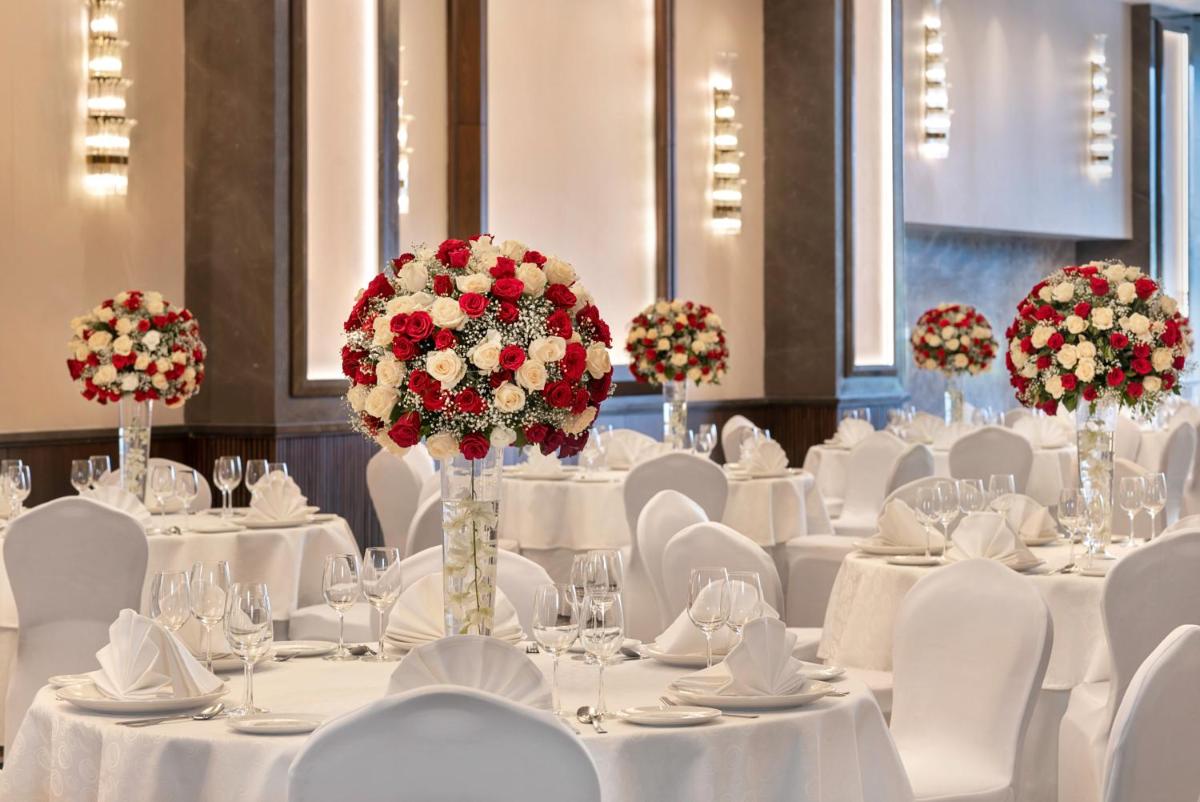 a banquet hall with white tables and white chairs at Hyatt Centric Rajpur Road Dehradun in Dehradun