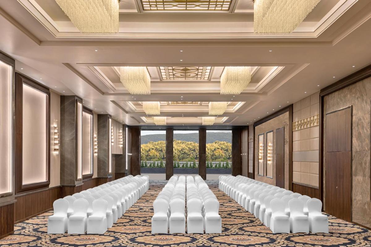 a row of white chairs in a room with a ceiling at Hyatt Centric Rajpur Road Dehradun in Dehradun