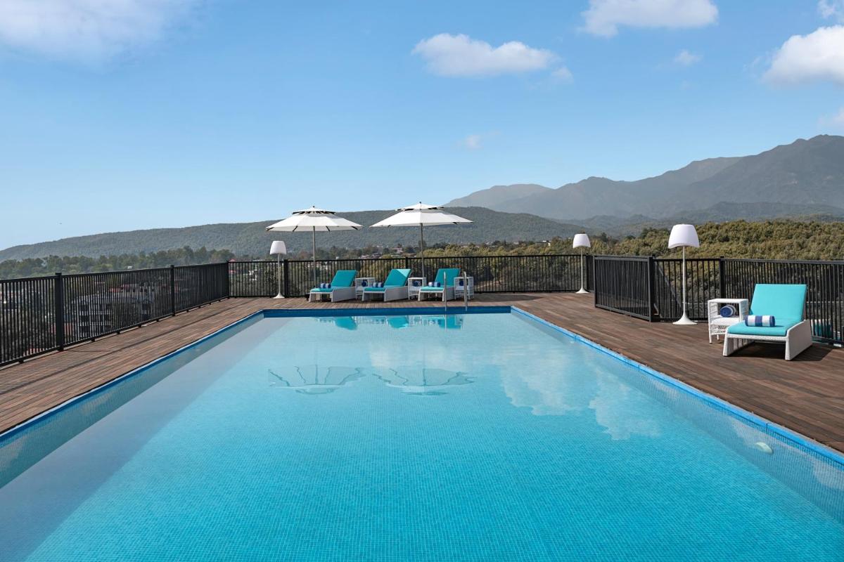 a swimming pool on a deck with a view of the mountains at Hyatt Centric Rajpur Road Dehradun in Dehradun