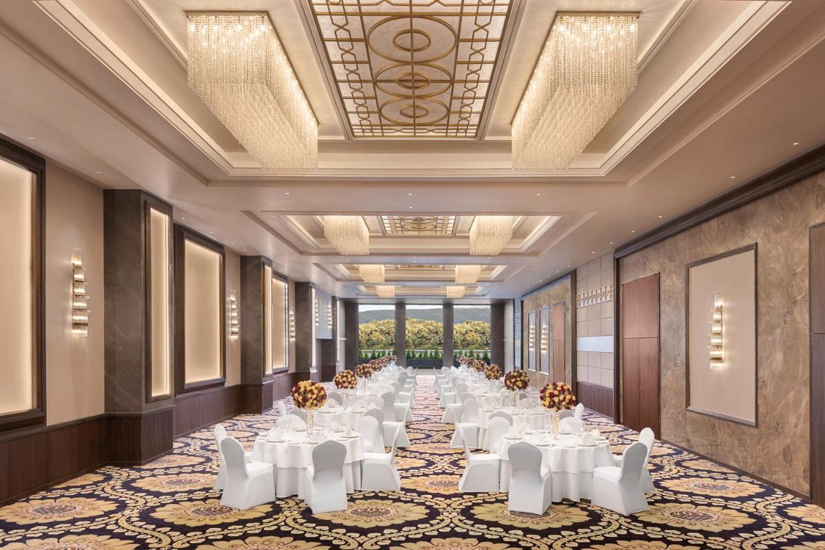 a long banquet hall with white tables and chairs at Hyatt Centric Rajpur Road Dehradun in Dehradun