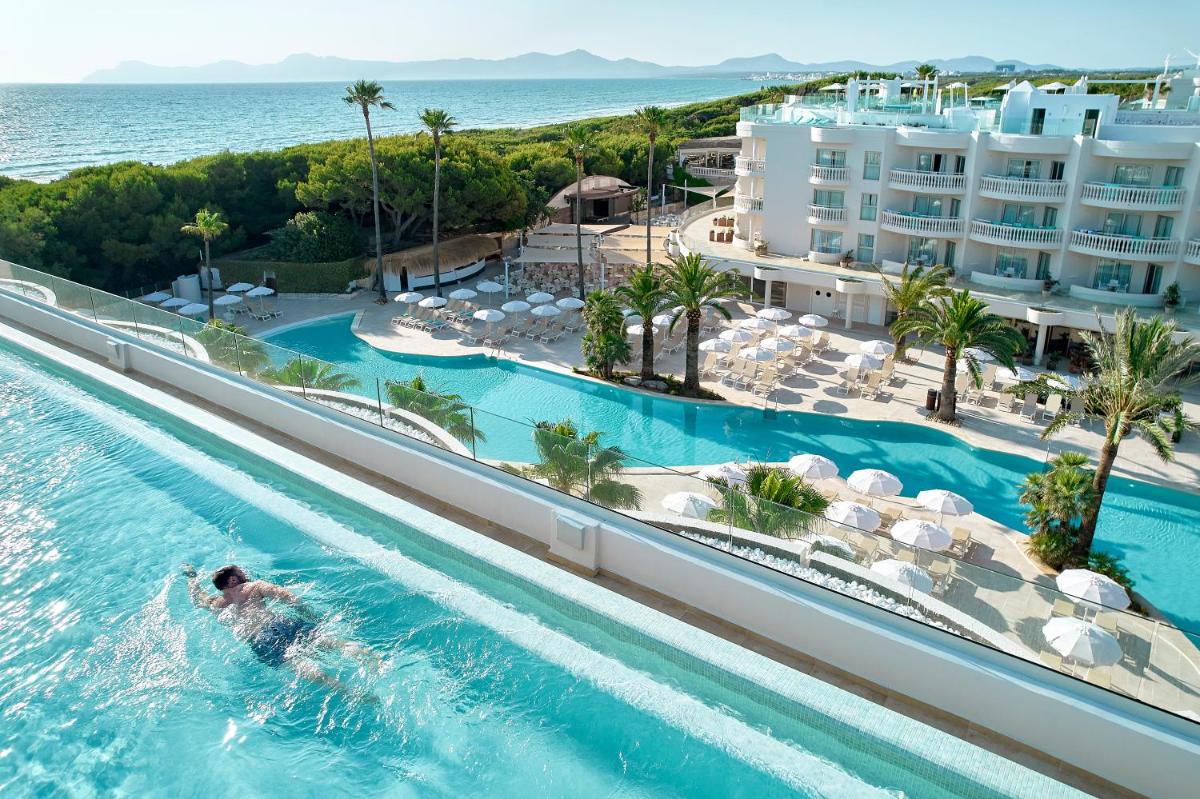una persona nadando en una piscina en un complejo turístico en Iberostar Selection Albufera Park All Inclusive, en Playa de Muro