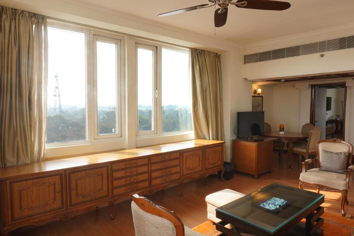 a living room with a table and some windows at Clarks Avadh in Lucknow
