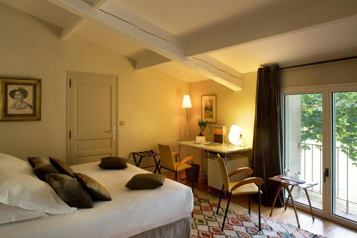 une chambre d'hôtel avec un lit, un bureau et une fenêtre dans l'établissement Hotel Château Des Alpilles, à Saint-Rémy-de-Provence