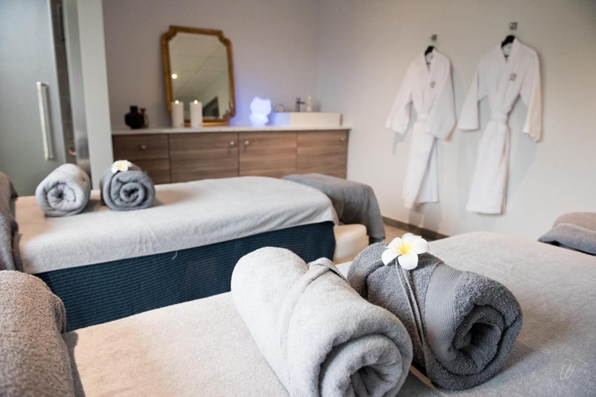 Cette chambre comprend 2 lits, des serviettes et un miroir. dans l'établissement Armes de Champagne, à Châlons-en-Champagne