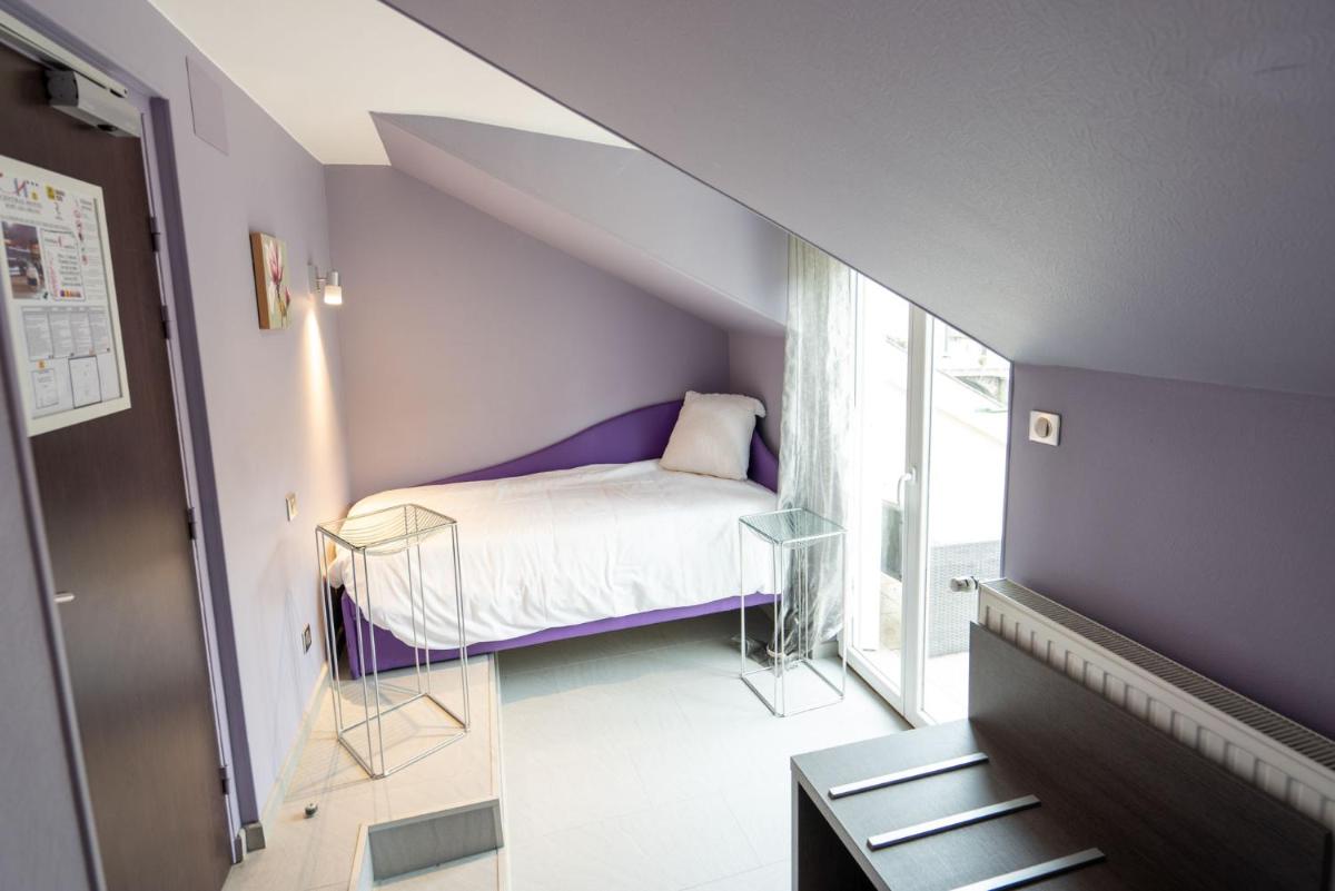 Un ou plusieurs lits dans un hébergement de l'établissement Logis Central Hôtel - Restaurant & Spa