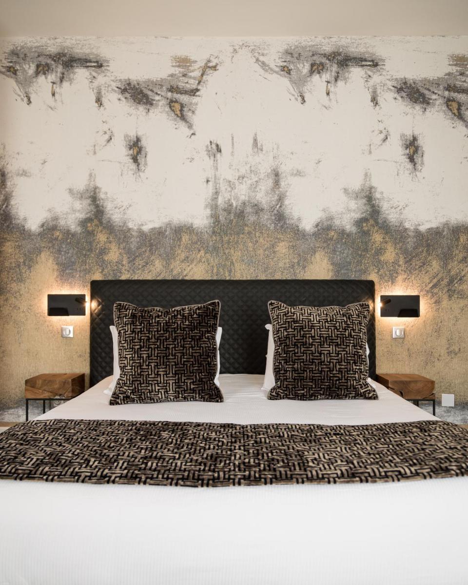 une chambre avec un grand lit avec deux oreillers dans l'établissement Maison Doucet - Relais & Châteaux, à Charolles