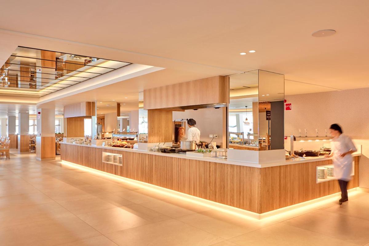 un restaurante con un mostrador con personas preparando comida en Universal Hotel Lido Park & Spa, en Paguera 76 fotos más