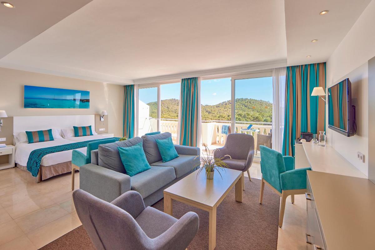 una habitación de hotel con un sofá y una cama en Universal Hotel Lido Park & Spa, en Paguera