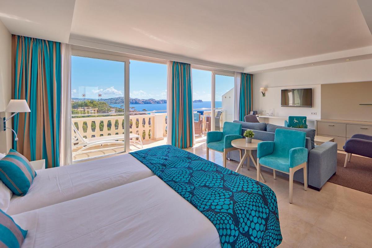 una habitación de hotel con una cama y un balcón en Universal Hotel Lido Park & Spa, en Paguera
