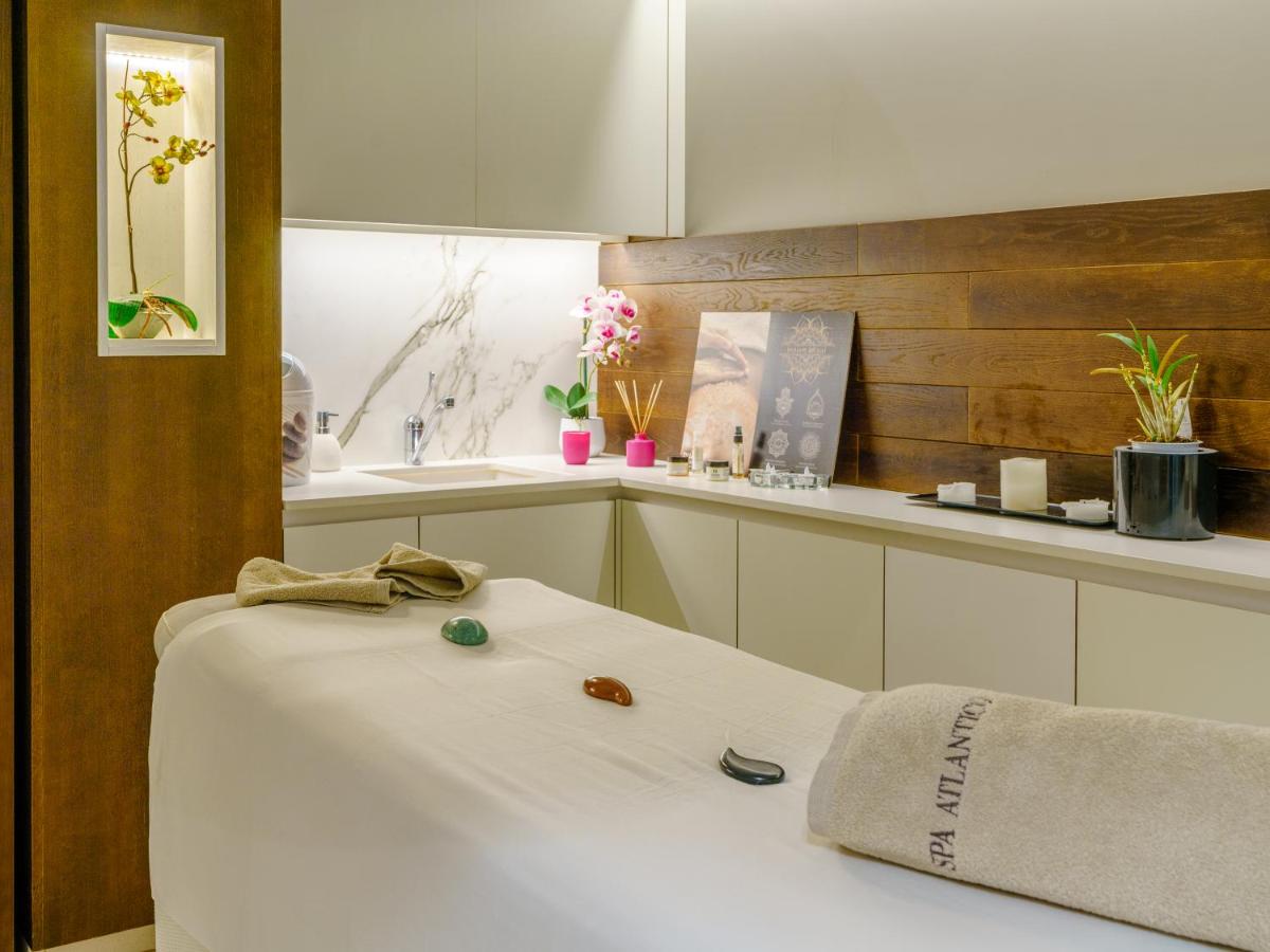 una cocina con armarios blancos y una cama blanca. en Hotel Spa Atlántico San Vicente do Mar, en San Vicente do Mar