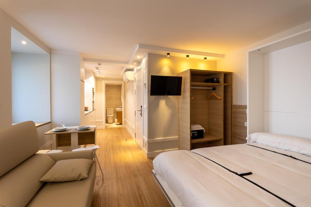 una habitación de hotel con una cama y un sofá en Apartamentos&Spa Mundakaport, en Mundaka