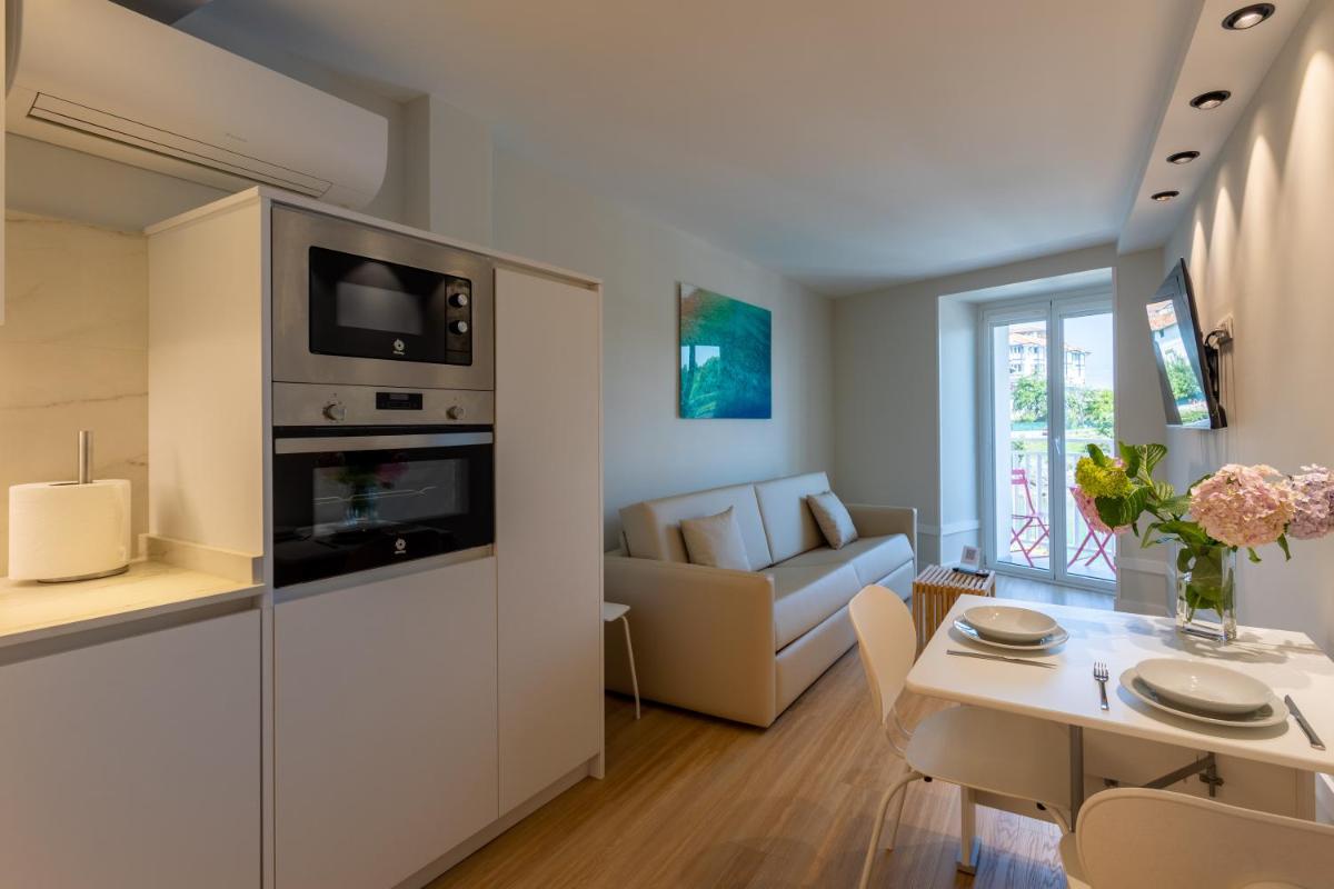 Una cocina y una sala de estar con una mesa y un sofá. en Apartamentos&Spa Mundakaport, en Mundaka