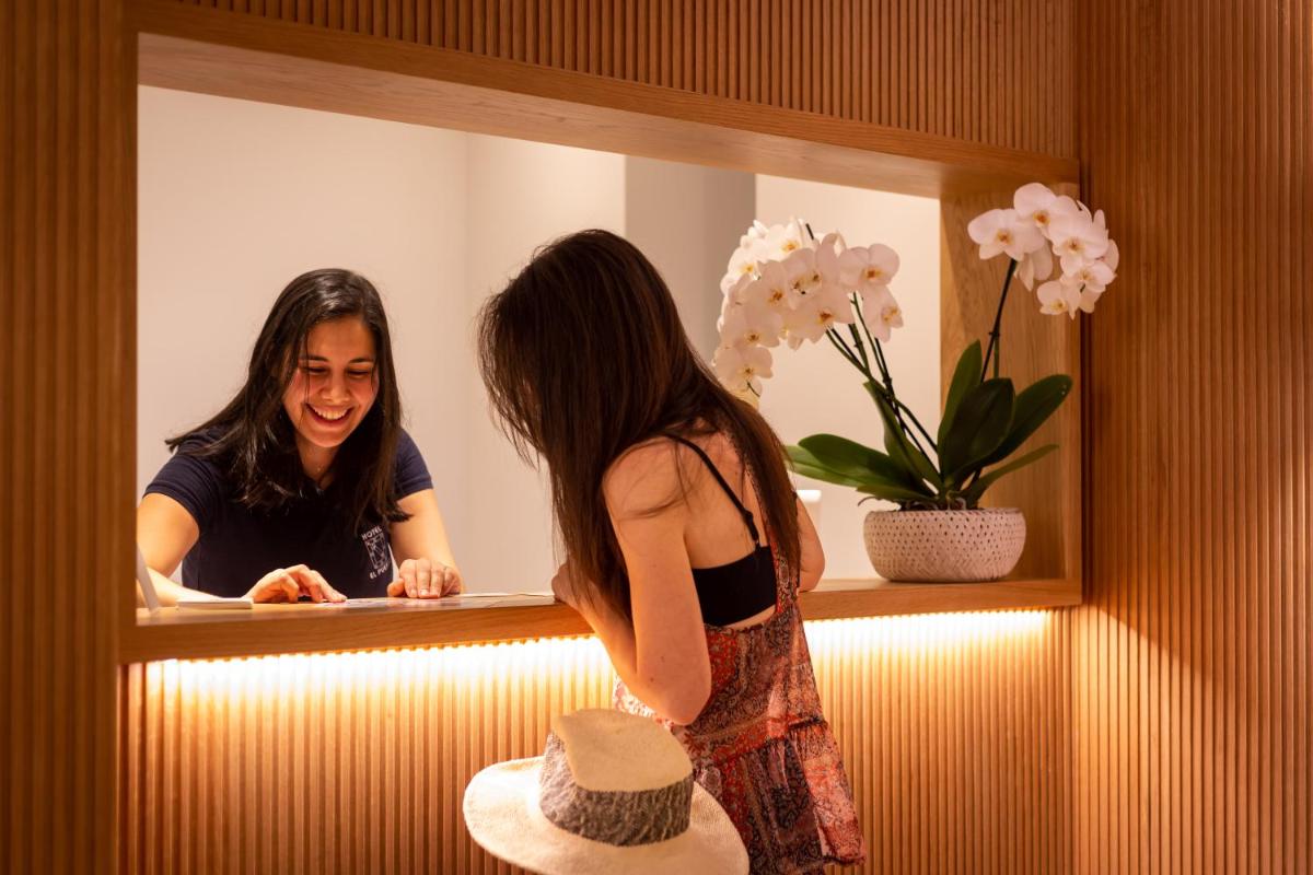 una mujer está mirando su reflejo en un espejo en Apartamentos&Spa Mundakaport, en Mundaka
