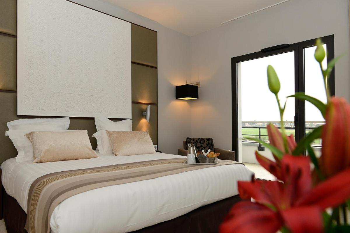 Un ou plusieurs lits dans un hébergement de l'établissement Kyriad Prestige Lyon Est - Saint Priest Eurexpo Hotel and SPA