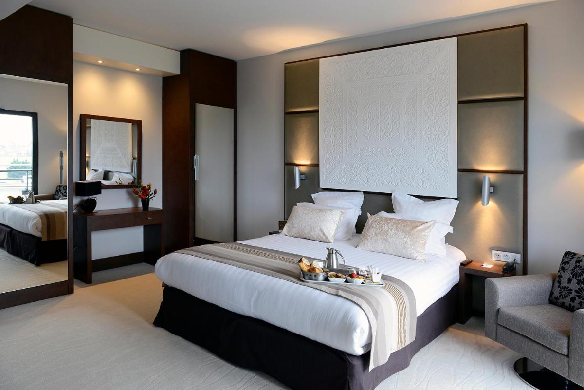 Un ou plusieurs lits dans un hébergement de l'établissement Kyriad Prestige Lyon Est - Saint Priest Eurexpo Hotel and SPA