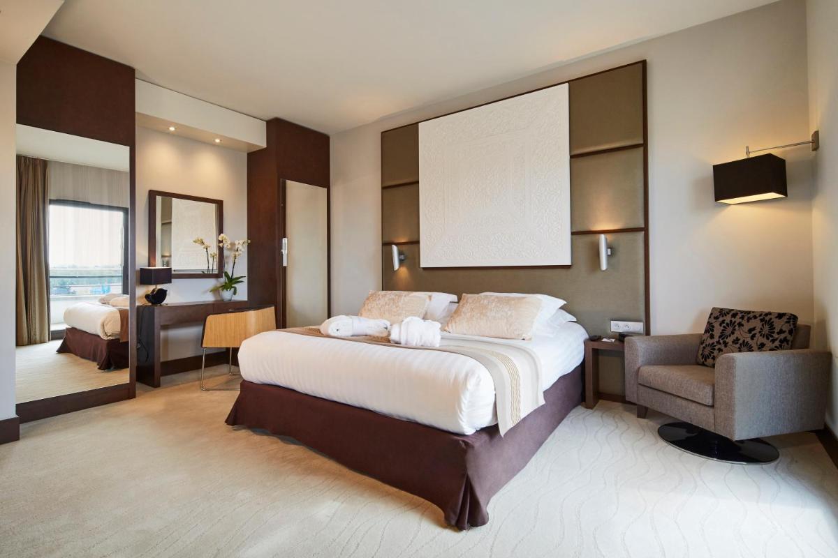 Un ou plusieurs lits dans un hébergement de l'établissement Kyriad Prestige Lyon Est - Saint Priest Eurexpo Hotel and SPA