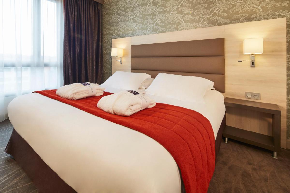 Un ou plusieurs lits dans un hébergement de l'établissement Kyriad Prestige Lyon Est - Saint Priest Eurexpo Hotel and SPA