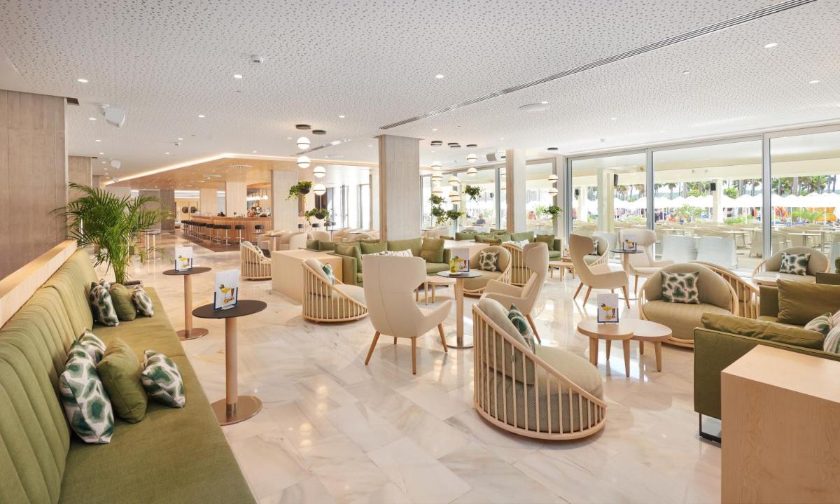 Un vestíbulo con sofás, mesas y sillas. en Hipotels Mediterraneo Hotel - Adults Only, en Sa Coma