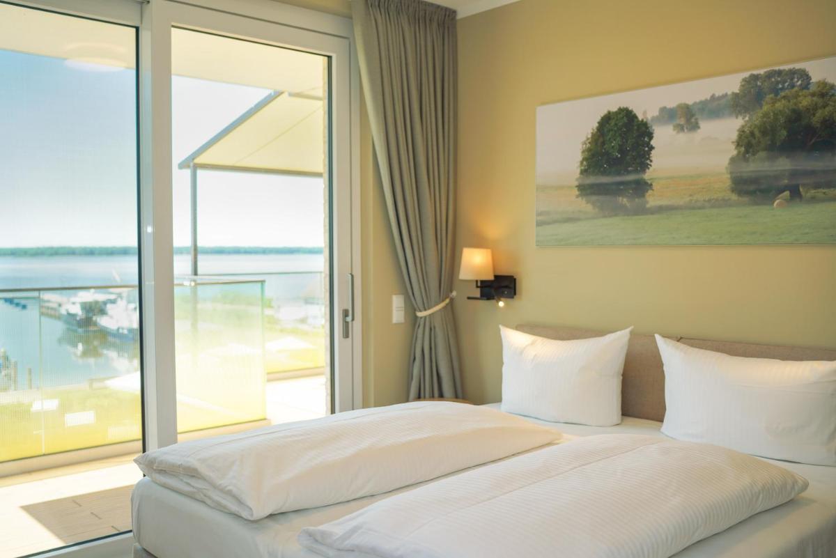 ein Schlafzimmer mit einem Bett mit Blick auf das Meer in der Unterkunft Appartements "Zum Leuchtturm" Hafen Rankwitz Insel Usedom in Rankwitz