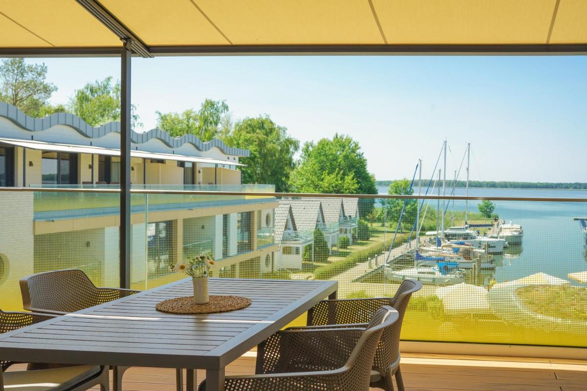 einen Tisch und Stühle auf einem Balkon mit Blick auf den Yachthafen in der Unterkunft Appartements "Zum Leuchtturm" Hafen Rankwitz Insel Usedom in Rankwitz