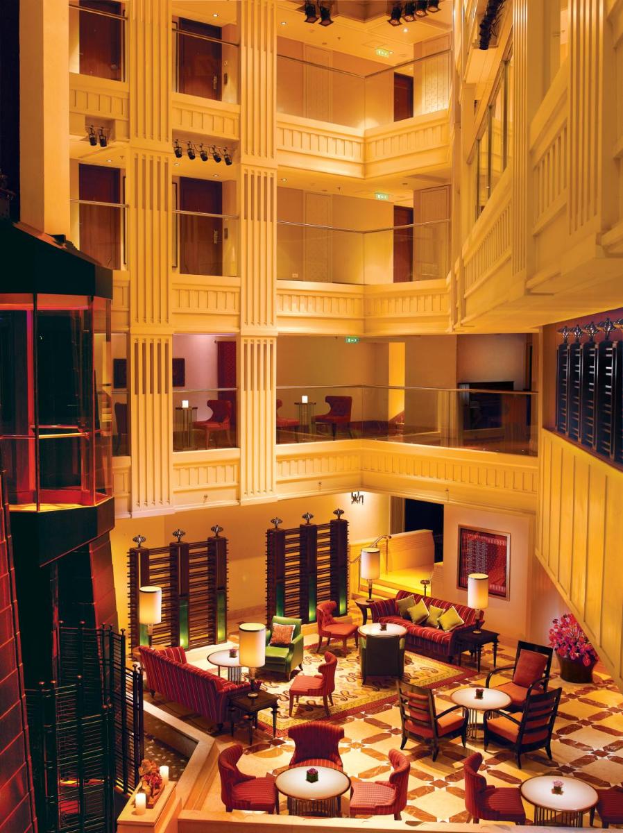 a large lobby with tables and chairs in a building at Hyderabad Marriott Hotel & Convention Centre in Hyderabad