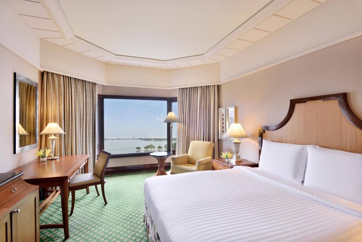 a hotel room with a bed and a desk and a window at Hyderabad Marriott Hotel & Convention Centre in Hyderabad a hotel room with a bed and a desk and a window at Hyderabad Marriott Hotel & Convention Centre in Hyderabad