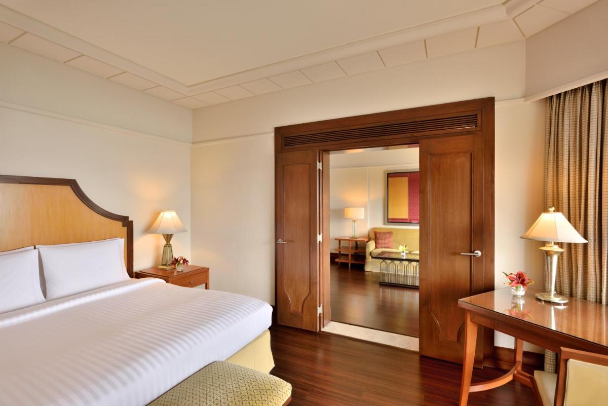 a hotel room with a bed and a desk and a bedroom at Hyderabad Marriott Hotel & Convention Centre in Hyderabad