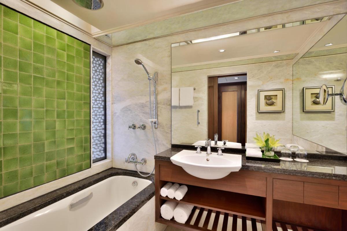 a bathroom with a sink and a bath tub and a sink at Hyderabad Marriott Hotel & Convention Centre in Hyderabad