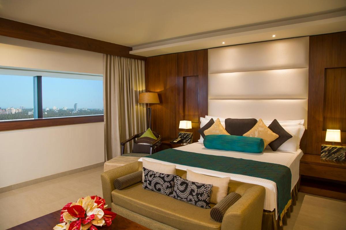a hotel room with a large bed and a couch at The Raviz Calicut in Kozhikode