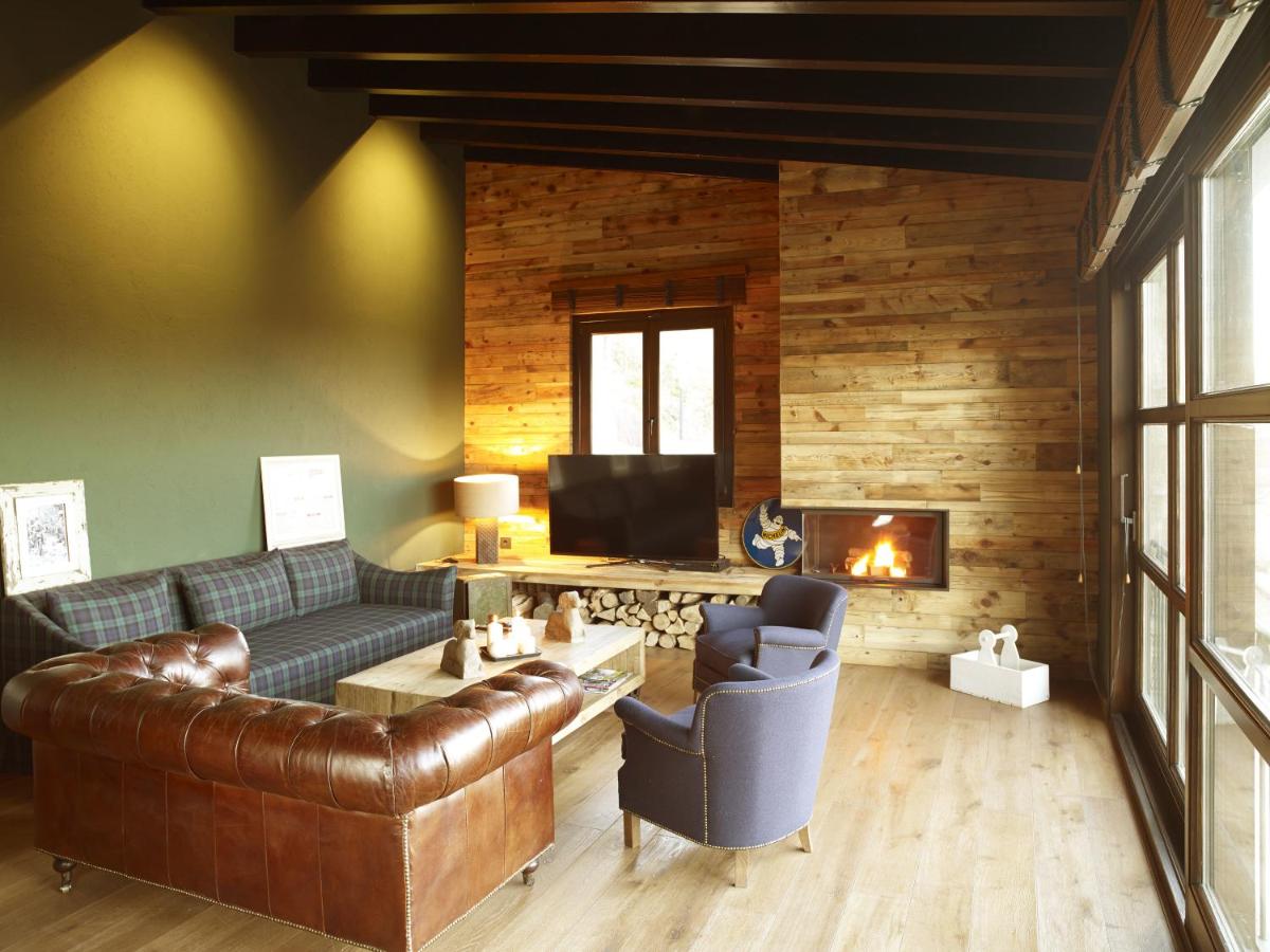 Una sala de estar con un sofá y una chimenea. en Hotel Boutique Puig Francó - Adults Only, en Camprodon