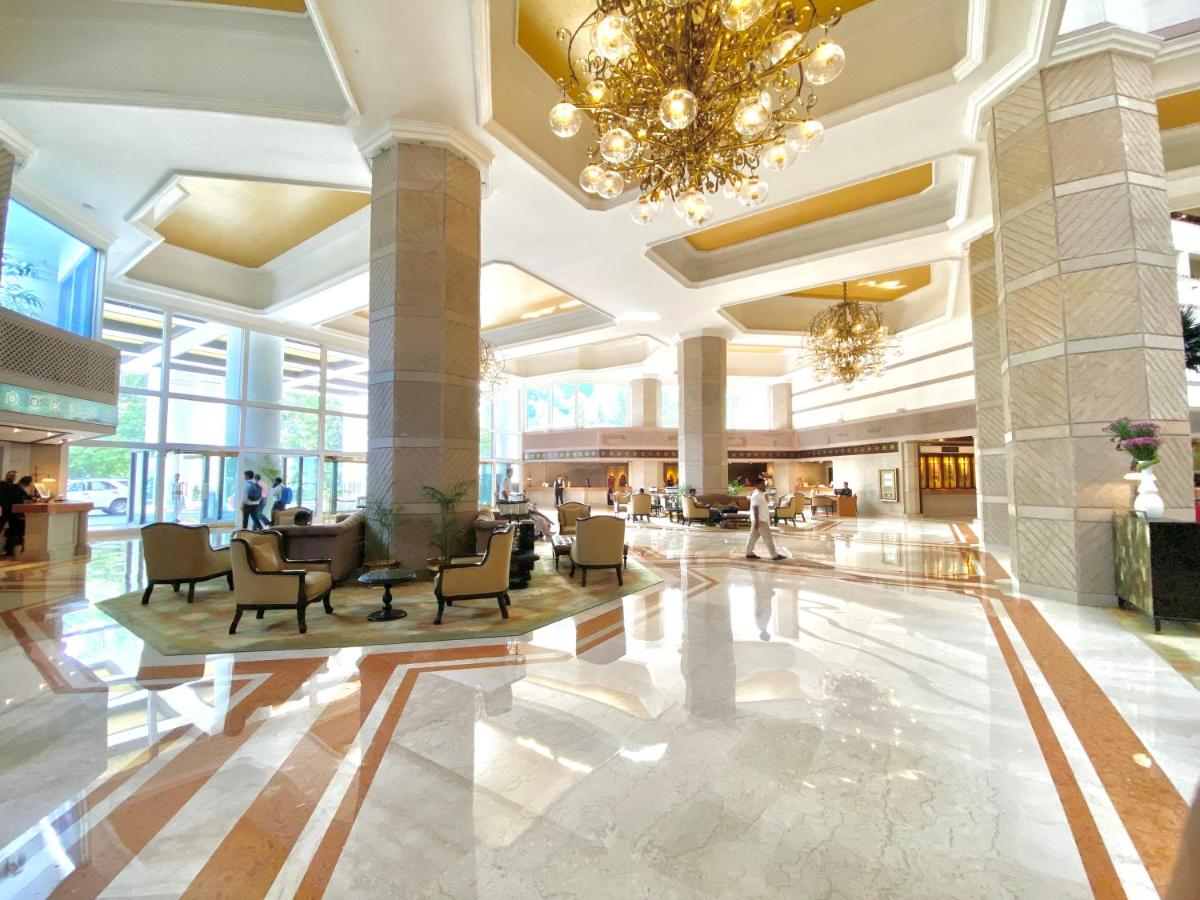 a lobby of a hotel with a chandelier at Taj Bengal in Kolkata