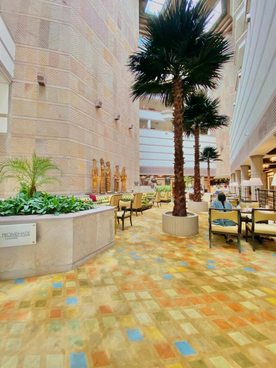 a lobby with a palm tree in a building at Taj Bengal in Kolkata