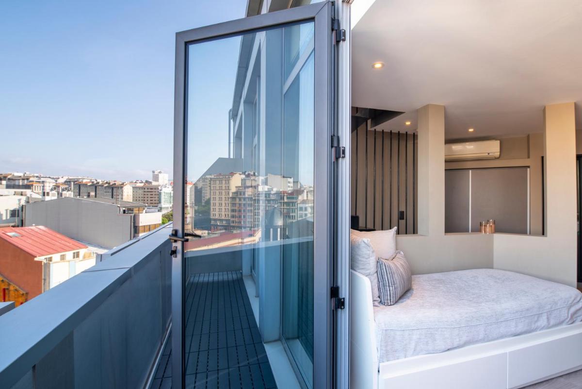 balcón con cama y vistas a la ciudad en Hotel Plaza, en A Coruña 148 fotos más