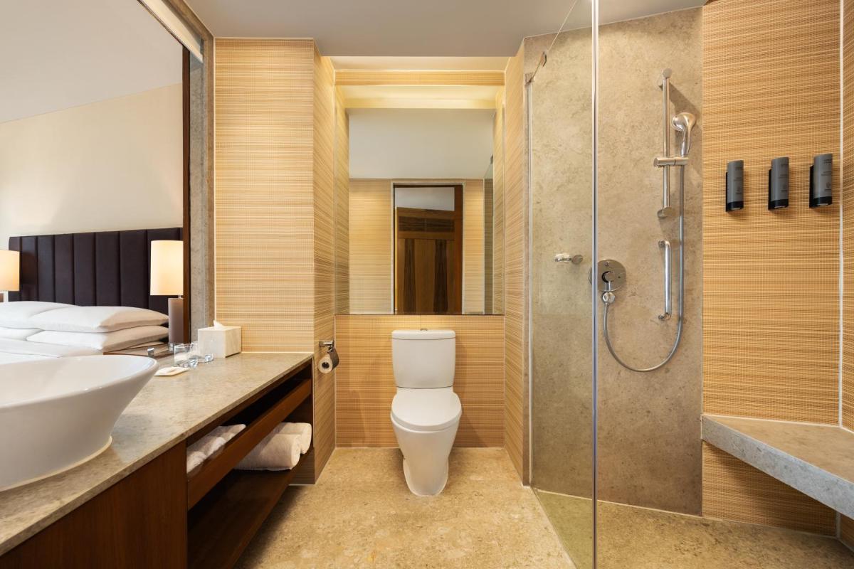 a bathroom with a shower and a toilet and a sink at Courtyard by Marriott Hyderabad in Hyderabad +42 photos
