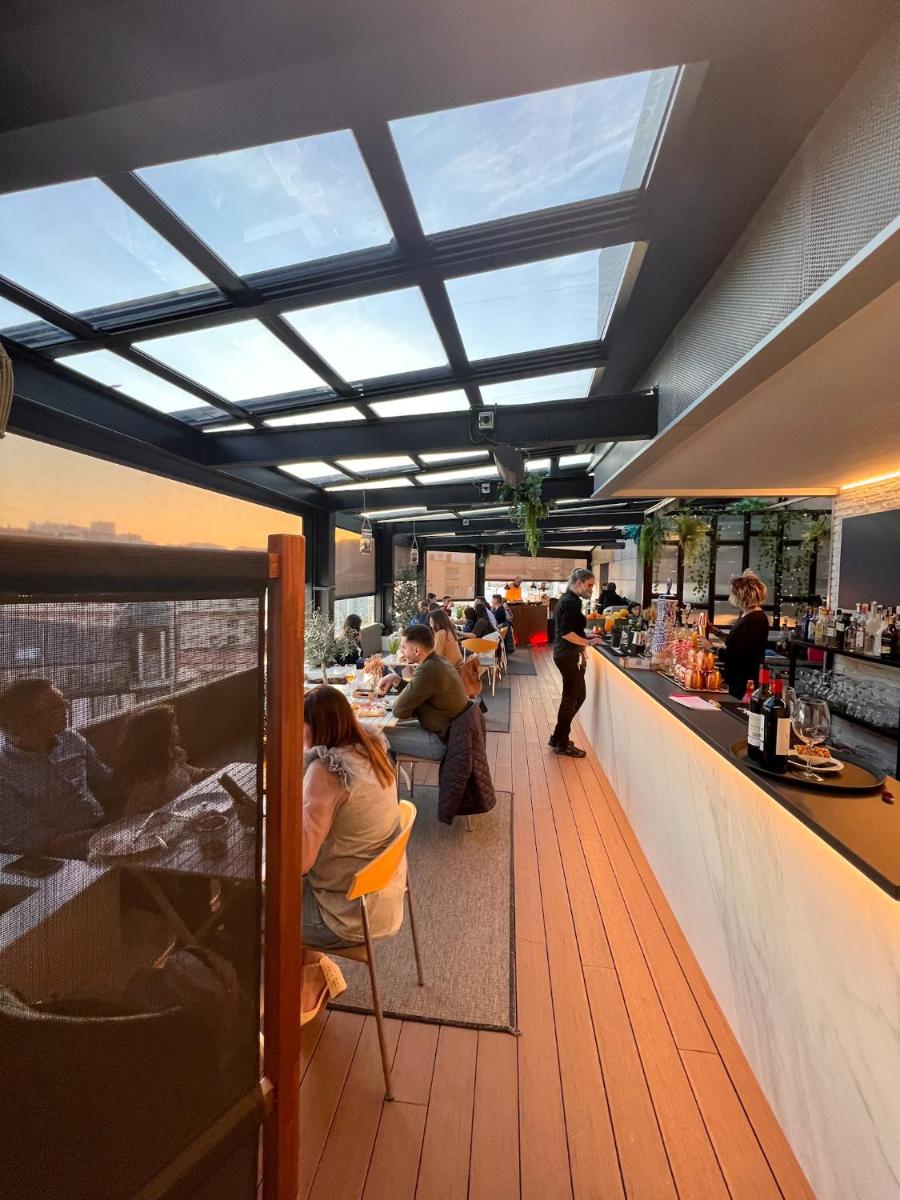 un restaurante con gente sentada en un bar en Hotel Plaza, en A Coruña