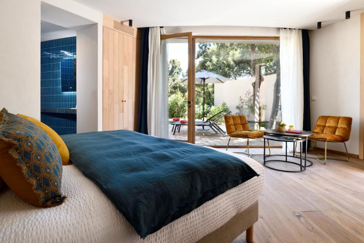 une chambre avec un lit, une table et des chaises dans l'établissement A SPERANZA Suites avec piscine privative chauffée, à Bonifacio 37 autres photos