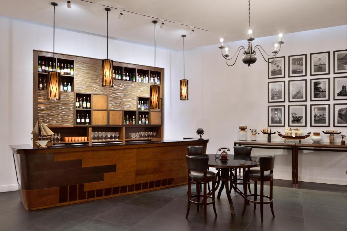a bar in a restaurant with a table and chairs at Kochi Marriott Hotel in Cochin