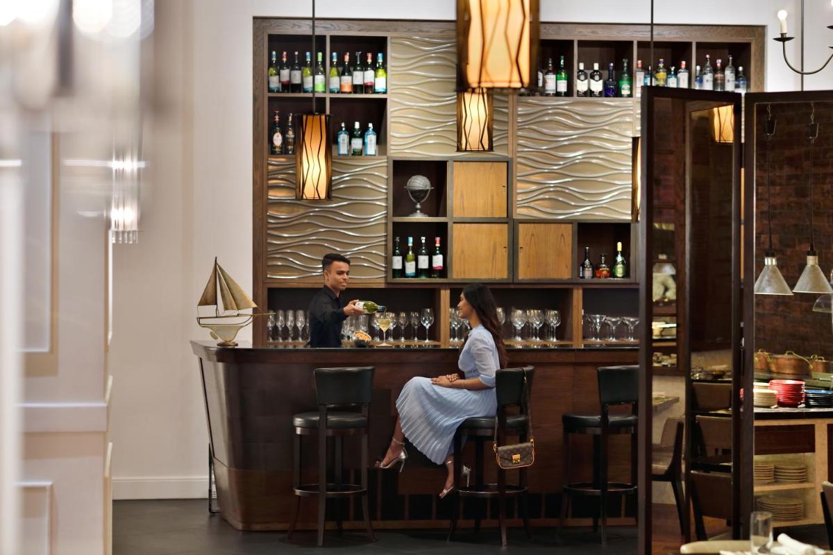 a man and a woman sitting at a bar at Kochi Marriott Hotel in Cochin