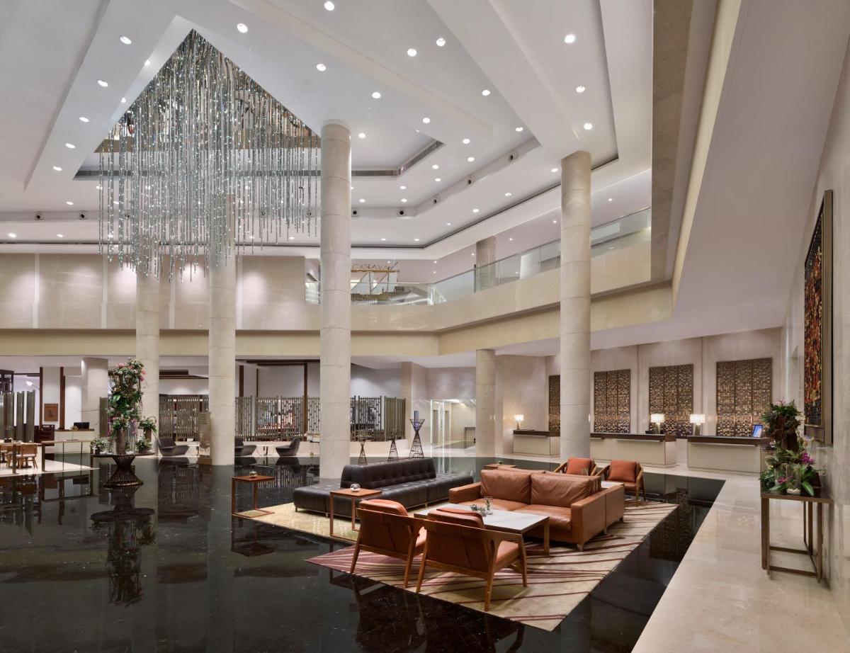 a large lobby with a large chandelier and a living room at Kochi Marriott Hotel in Cochin