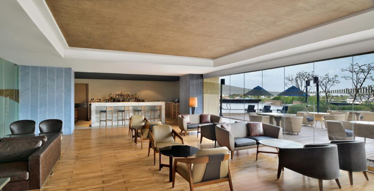 a lobby with couches and chairs and a bar at Kochi Marriott Hotel in Cochin