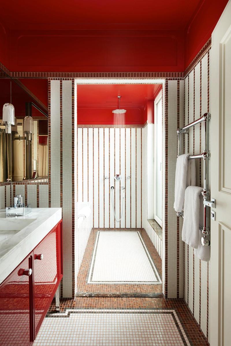La salle de bains rouge est pourvue d'une douche et d'un lavabo. dans l'établissement Villa-des-Prés, à Paris