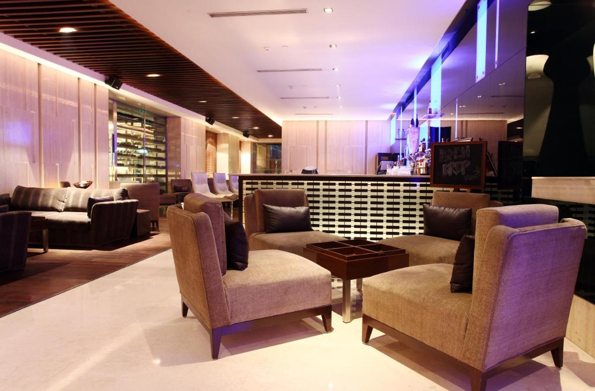 a waiting room with couches and chairs and a table at The LaLiT New Delhi in New Delhi