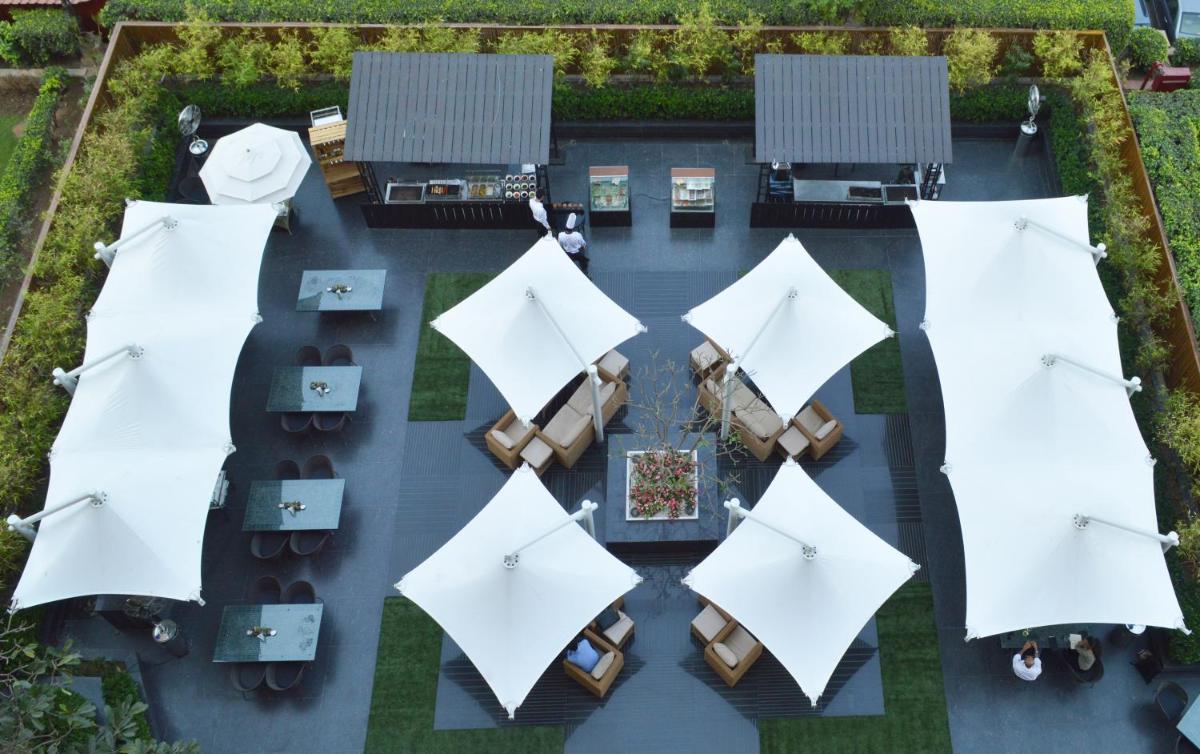 an overhead view of a patio with white umbrellas at The LaLiT New Delhi in New Delhi