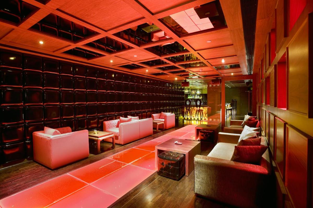 a bar with couches and a fireplace in a room at The LaLiT New Delhi in New Delhi