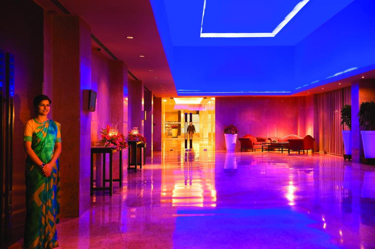 a person standing in a room with purple lights at The LaLiT New Delhi in New Delhi +84 photos